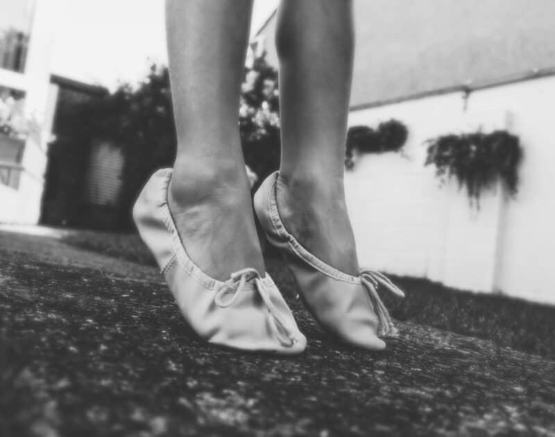 a black and white photo of a woman's feet in ballet shoes